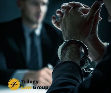 criminal defense lawyer speaks to client in handcuffs